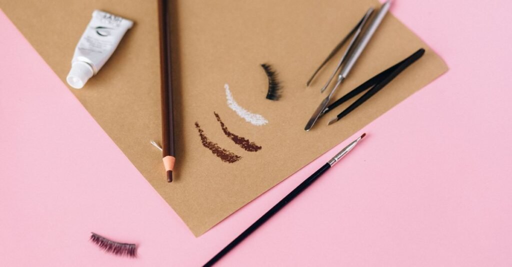 Eyebrow pencils, brushes, and product swatches flat lay