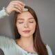 Woman using a jade gua sha tool to massage her face