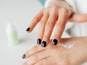Woman applying hand cream to the back of her hand for soft, hydrated skin
