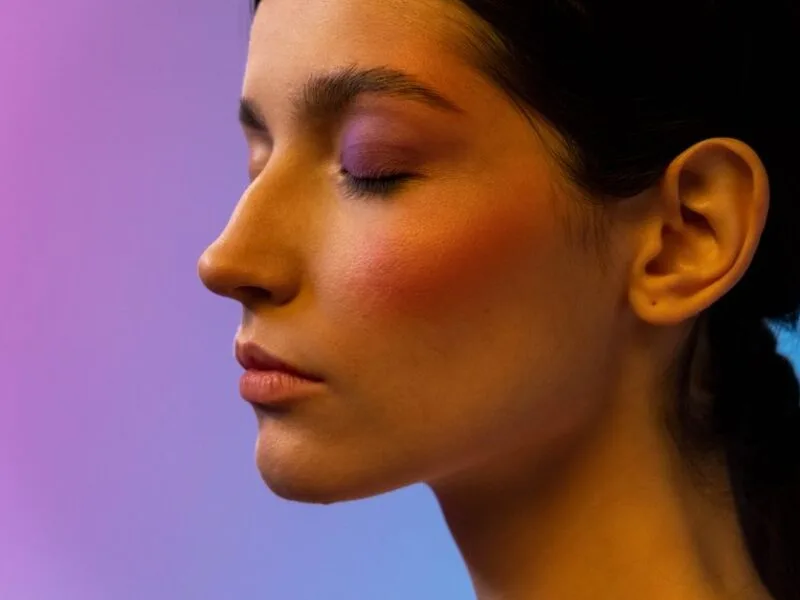 Close-up of a soft dewy cream blush flush on a woman's cheek