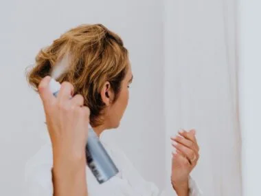 Woman spraying a leave-in conditioner into her hair