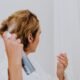 Woman spraying a leave-in conditioner into her hair