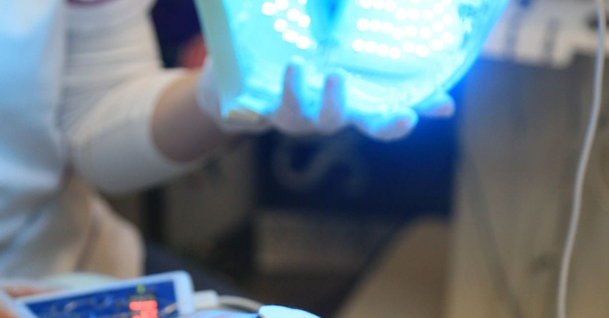 Woman using an LED light therapy mask