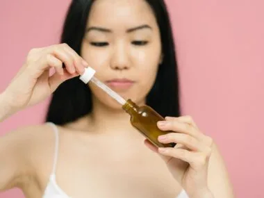 Woman using a retinol serum dropper