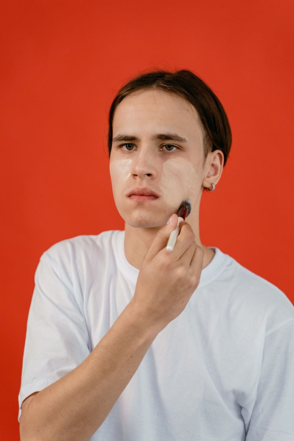 Applying liquid foundation to the face with a brush