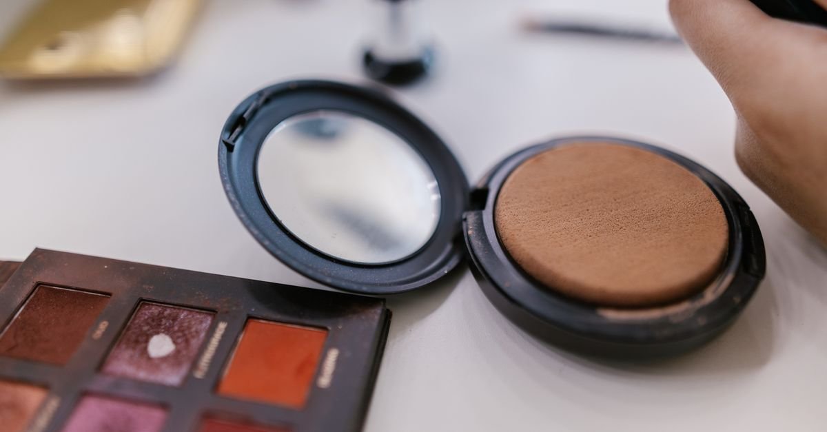 An open cushion compact with its applicator puff