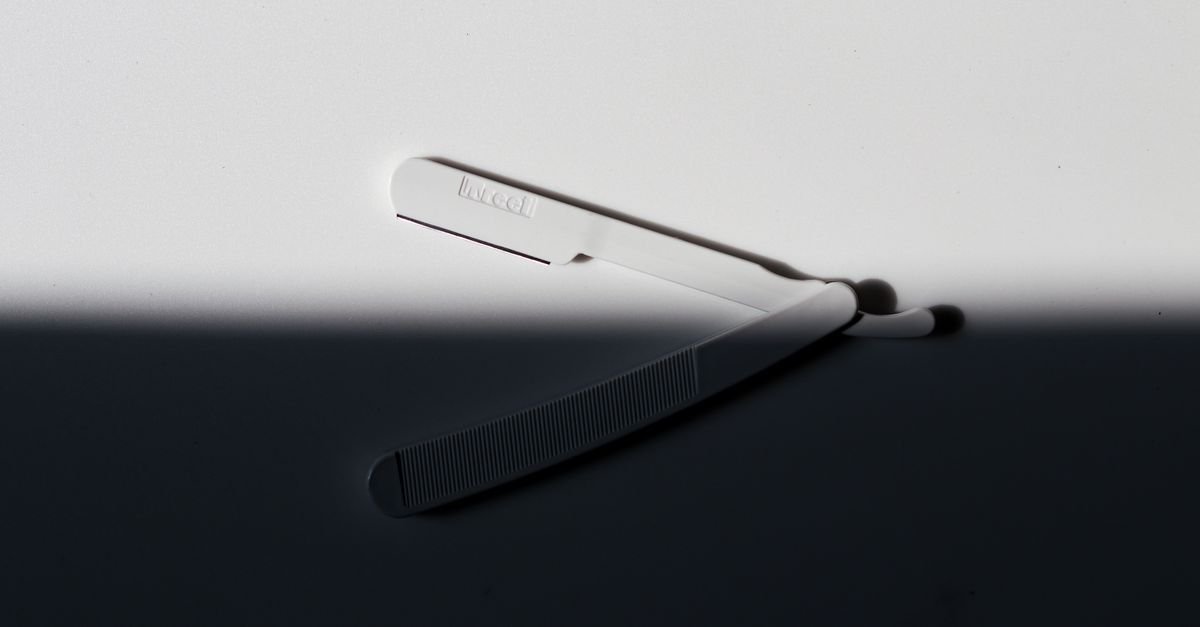 A single-blade facial razor on a dark surface