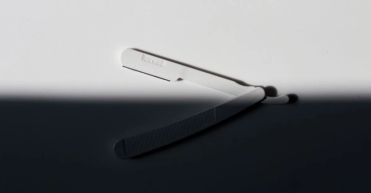 A single-blade facial razor on a dark surface