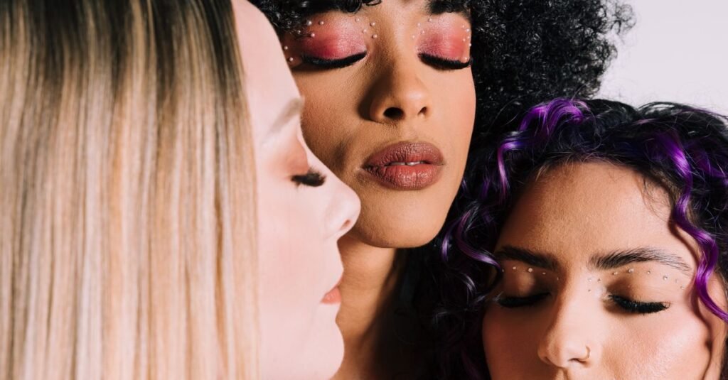 Three women with diverse skin tones in close-up