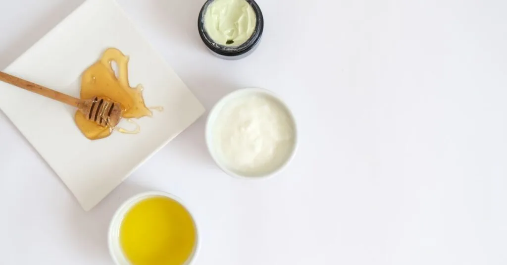 Honey dipper and creams on a white flat lay