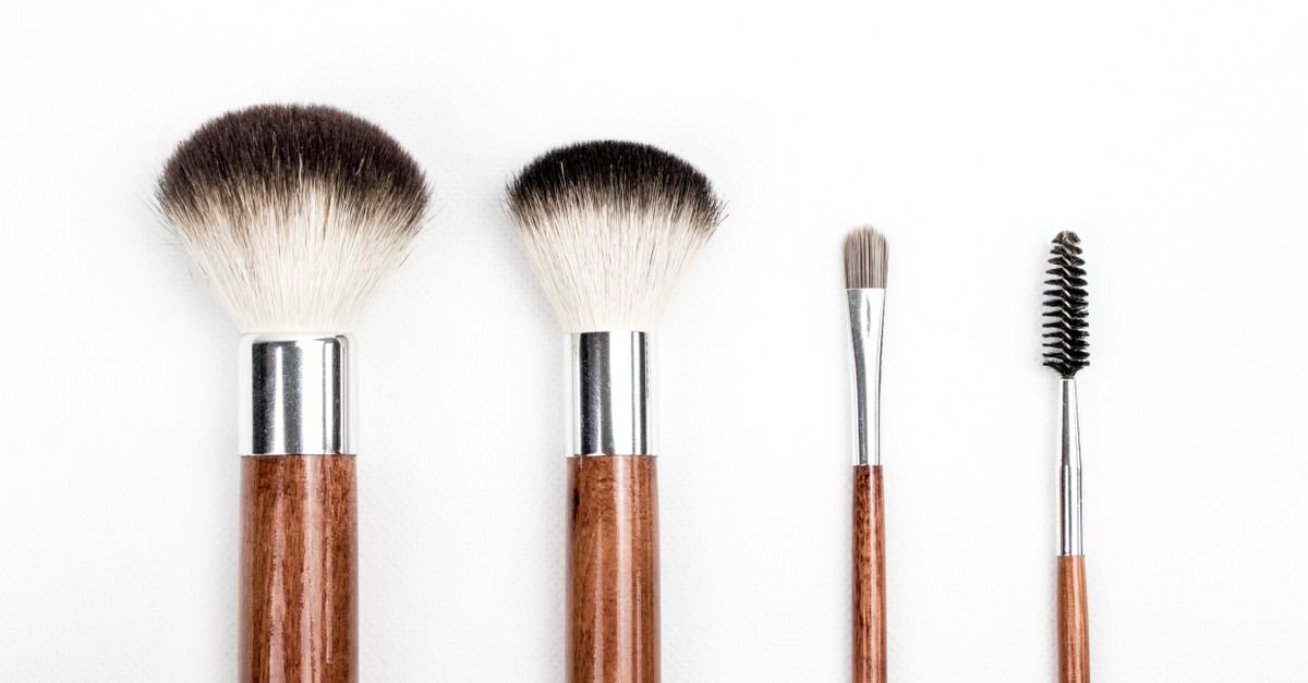 A lineup of clean makeup brushes on white