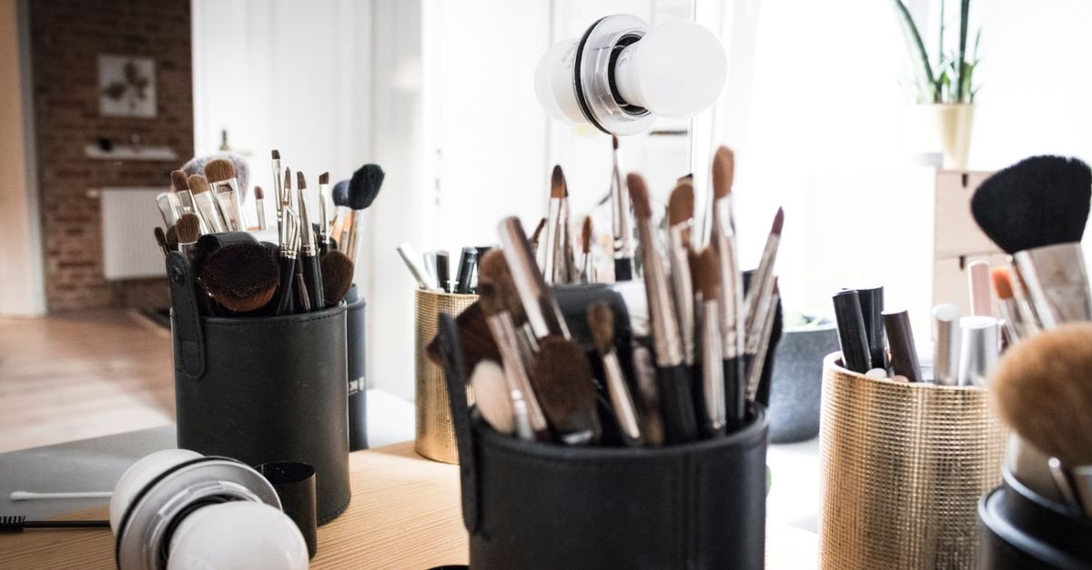 Organized makeup brushes in cups on a vanity