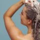 A woman lathering shampoo into her scalp