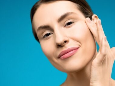 A woman with natural skin touching her cheek