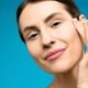 A woman with natural skin touching her cheek