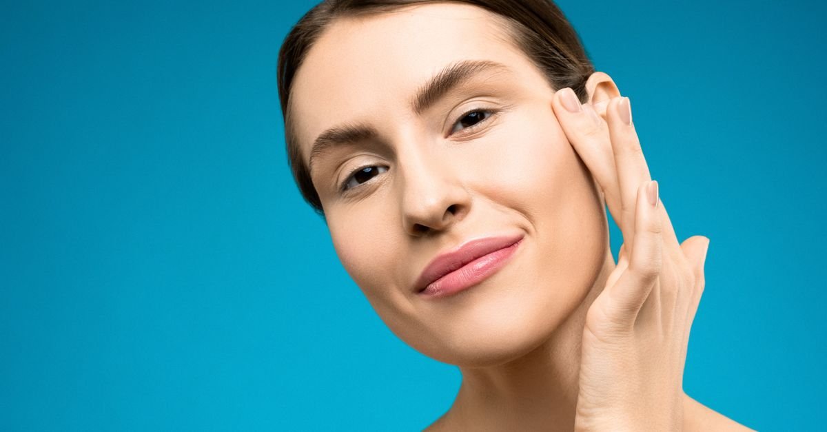 Woman with clear skin touching her cheek