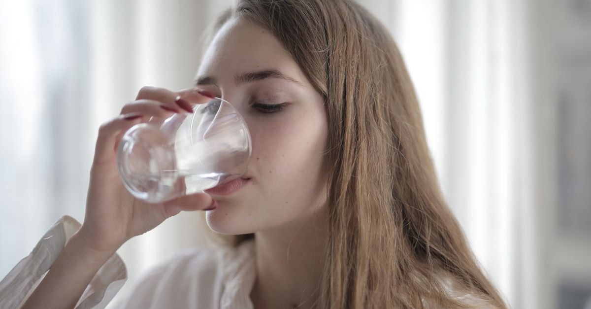 A woman drinking a glass of water