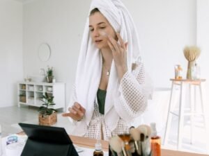 A woman in a towel doing her evening skincare routine