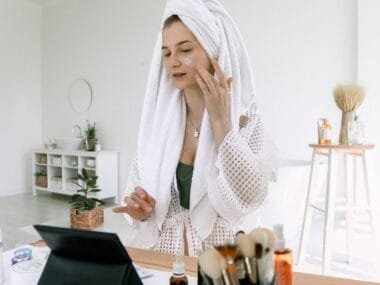 A woman in a towel doing her evening skincare routine