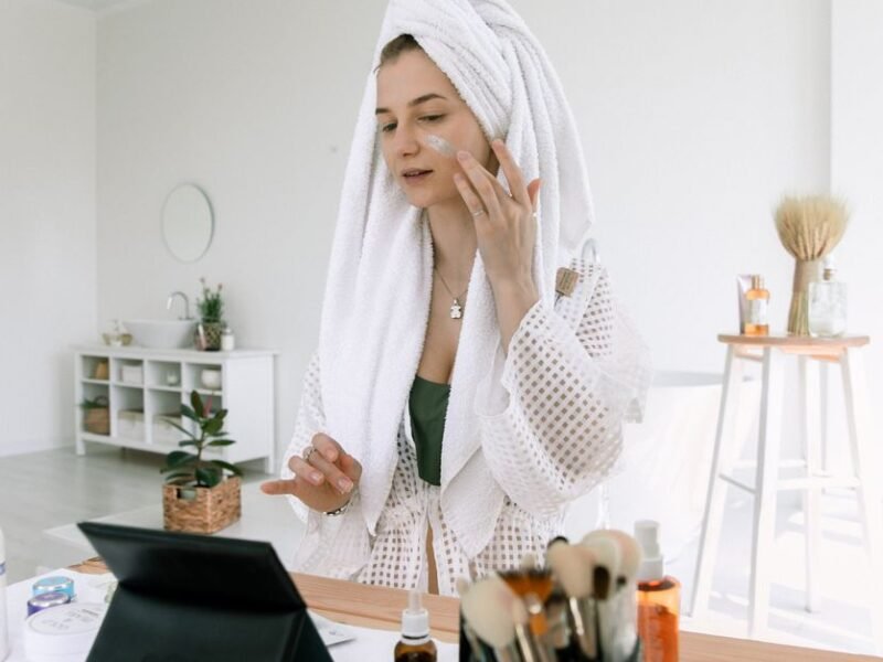 A woman in a towel doing her evening skincare routine