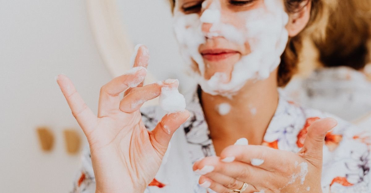 A woman cleansing her face with foam