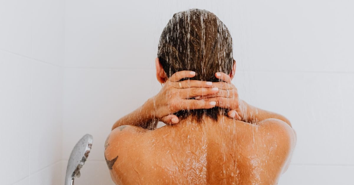A woman rinsing her hair under the shower