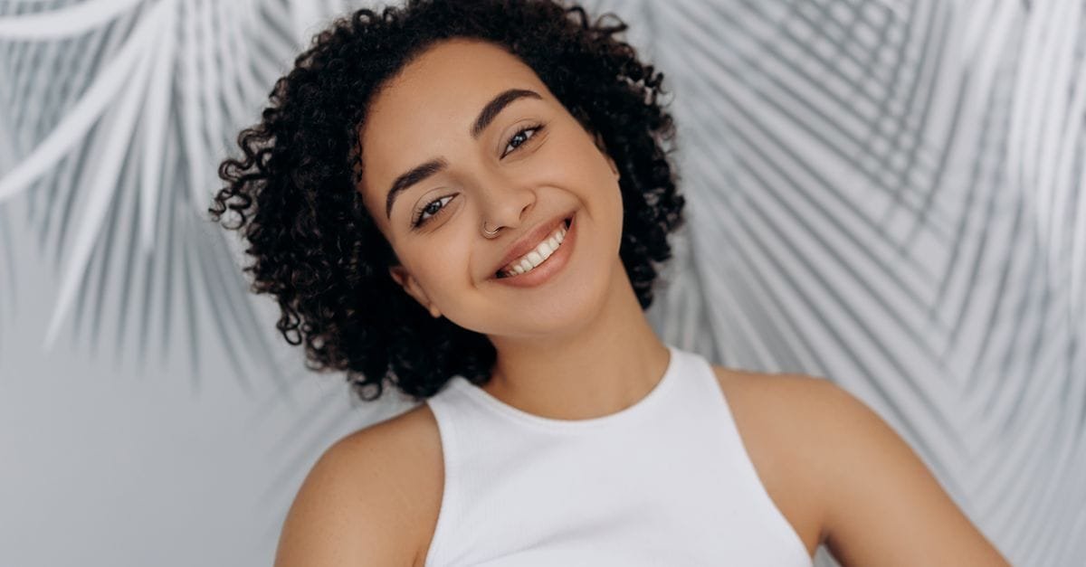 A smiling woman with healthy natural curls