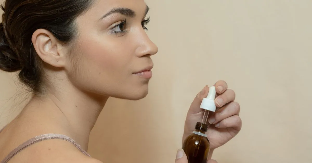 A woman holding amber oil bottles