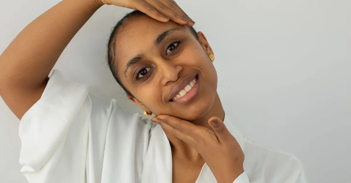 A smiling woman touching her smooth cheek
