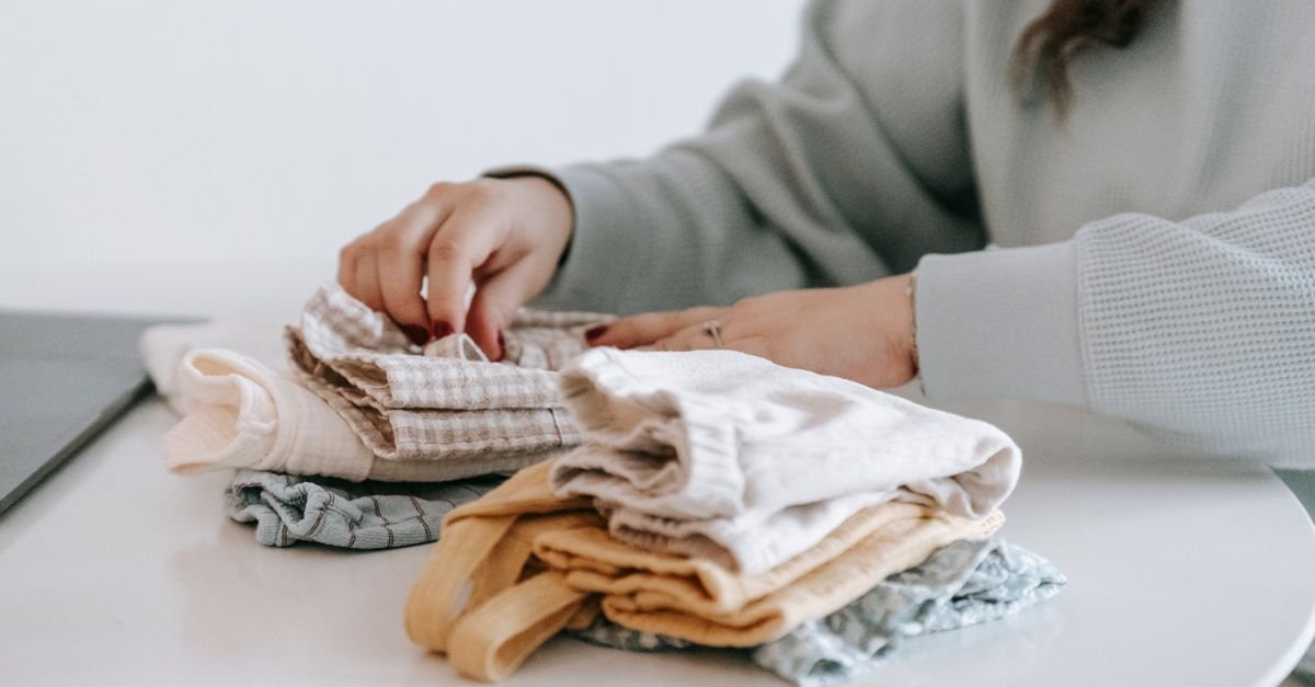 Hands folding clean laundry on a table