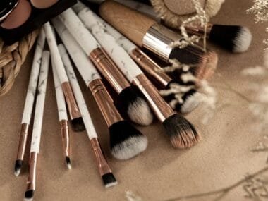 A collection of makeup brushes in a flat lay