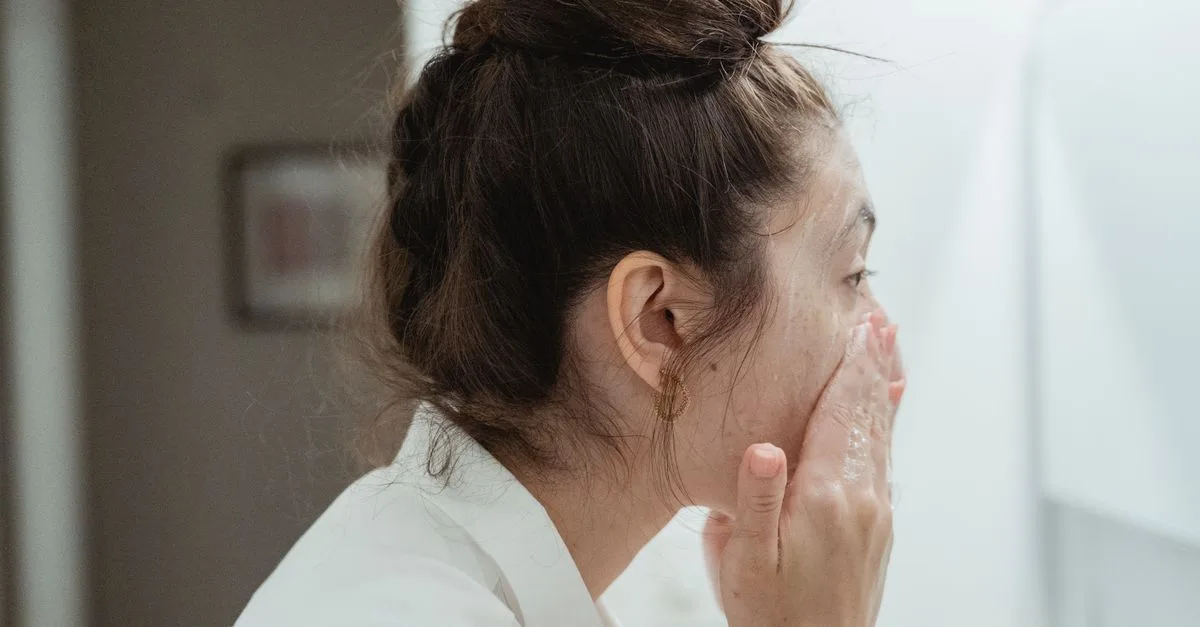 A teen washing her face at the bathroom sink
