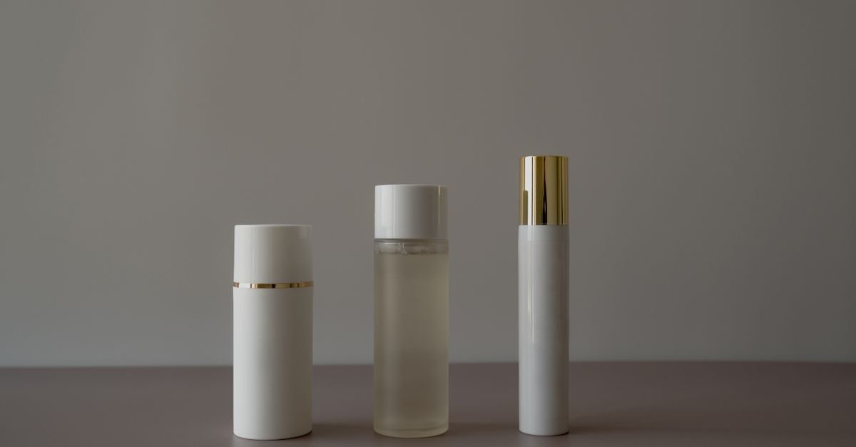 Three minimal unbranded skincare bottles on a neutral background
