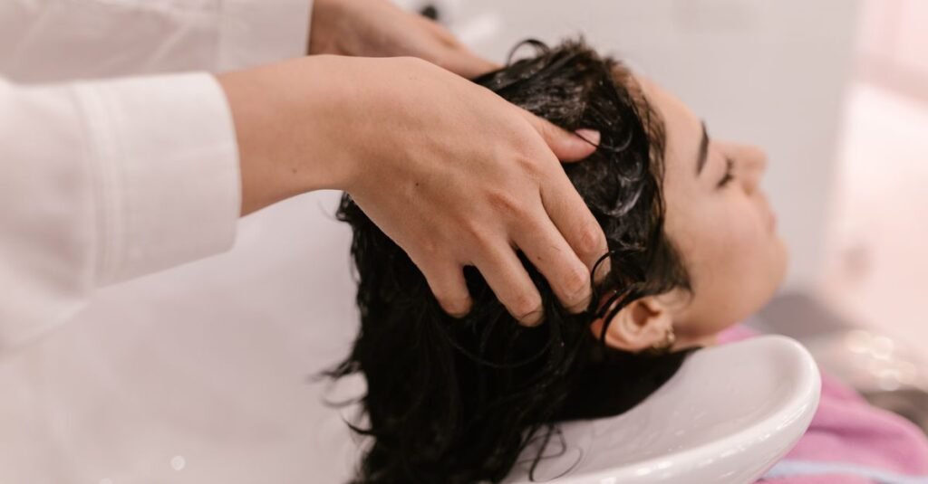 Hands massaging shampoo at a salon basin
