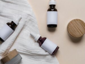 Amber skincare bottles with wooden caps in a minimal flat lay