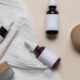 Amber skincare bottles with wooden caps in a minimal flat lay