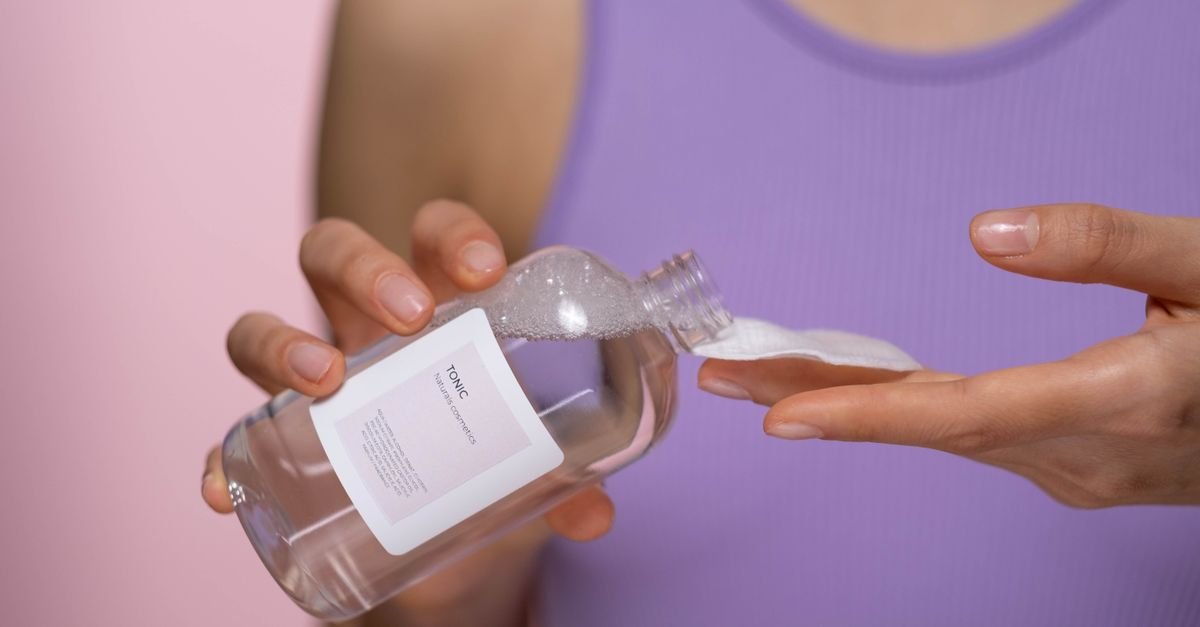Pouring exfoliating toner onto a cotton pad