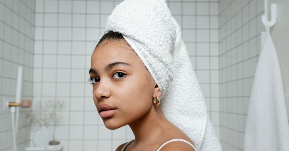 A woman with her hair wrapped in a white towel
