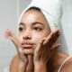 A teenage girl with a towel washing her face
