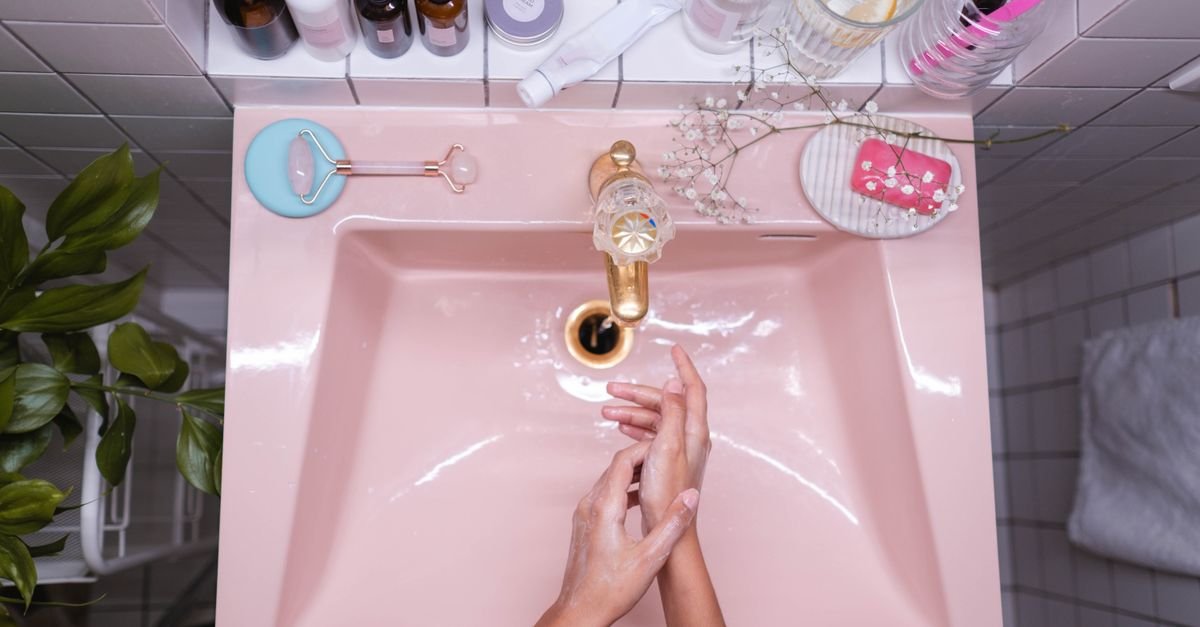 Washing hands and tools over a pink sink