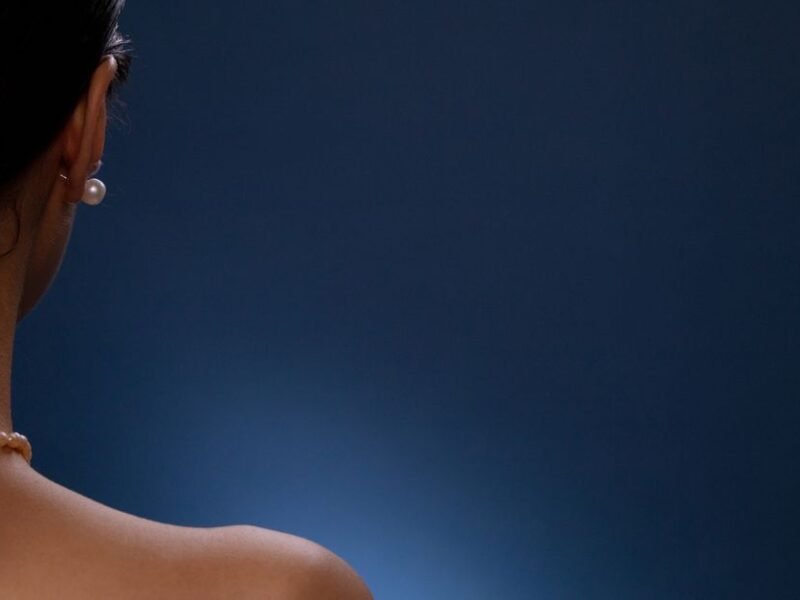 The back and shoulders of a woman against a dark background