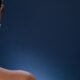 The back and shoulders of a woman against a dark background