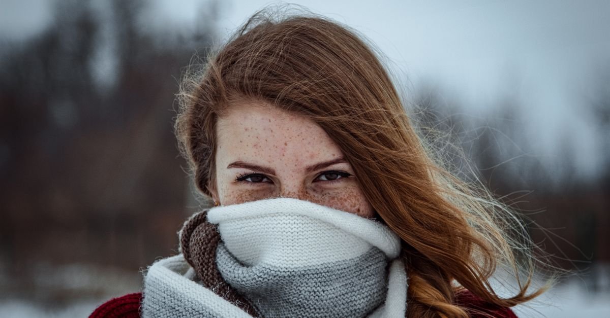 A woman in winter with a scarf over her mouth