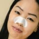 Using a pore strip to remove blackheads on the nose