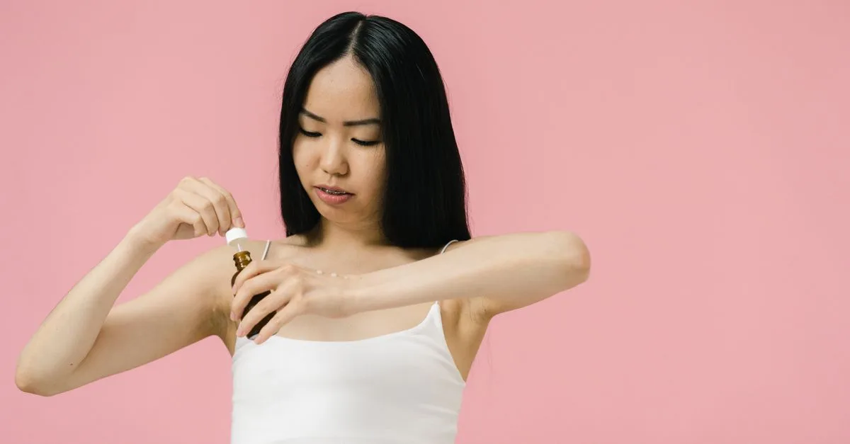 A woman applying serum to her inner arm