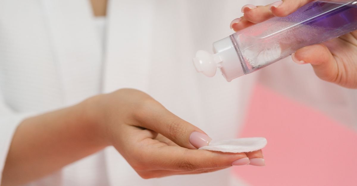 A hand dispensing toner onto a cotton pad