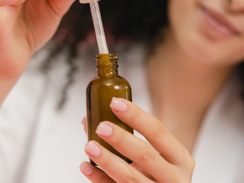 A woman using a niacinamide serum dropper