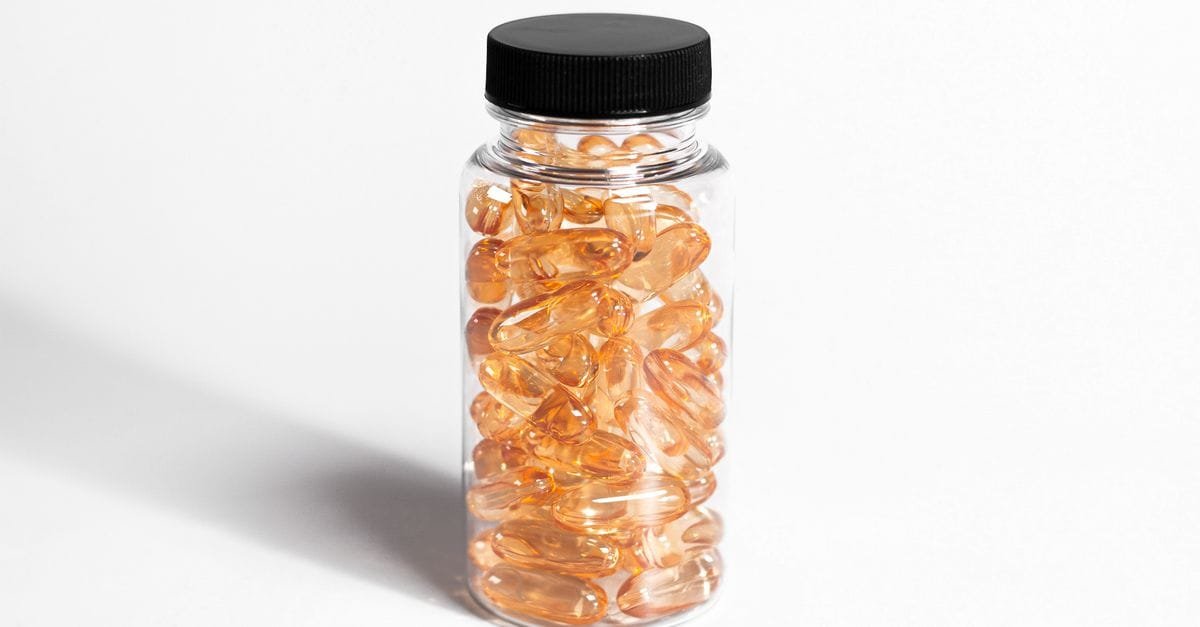 A jar of golden supplement capsules