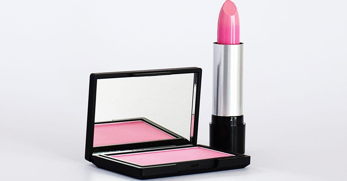 A pink blush compact and lipstick on white