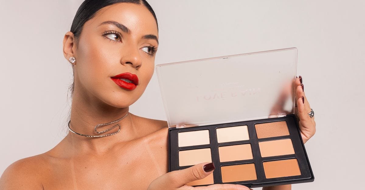 A model holding a palette of foundation shades